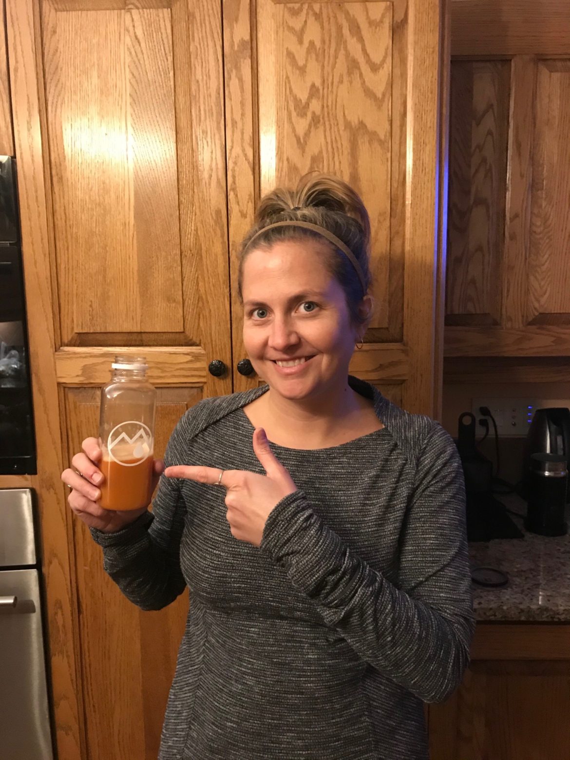 woman holding half empty juice bottle